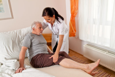 caregiver assisting her patient to bed